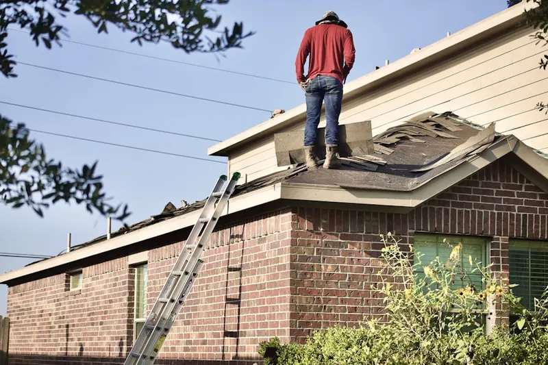 Professional roofer working on a residential roof in Bastogne Gables